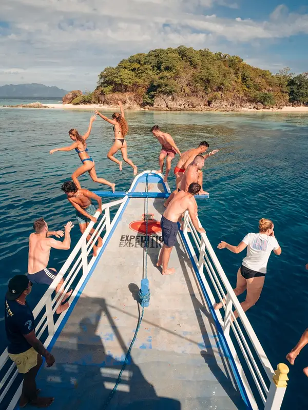 Viajeros saltando de la proa en un banco de arena de Coron
