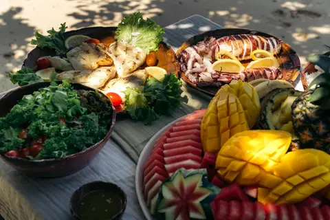 Fresh grilled seafood, salad, and tropical fruit served during a Seatours private speedboat charter in El Nido